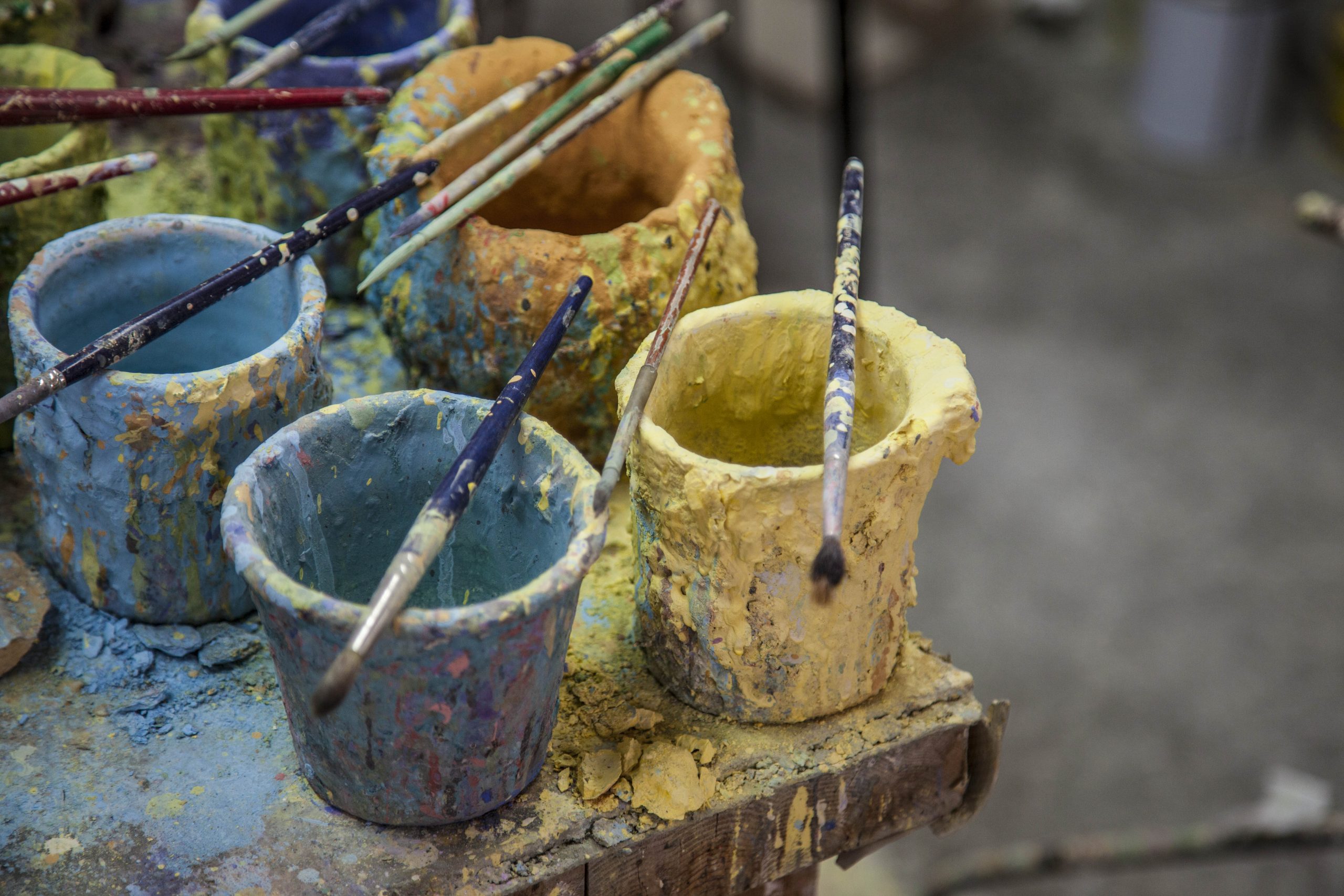 Banco del decoratore, vaschette con smalti bl e gialli e pennelli