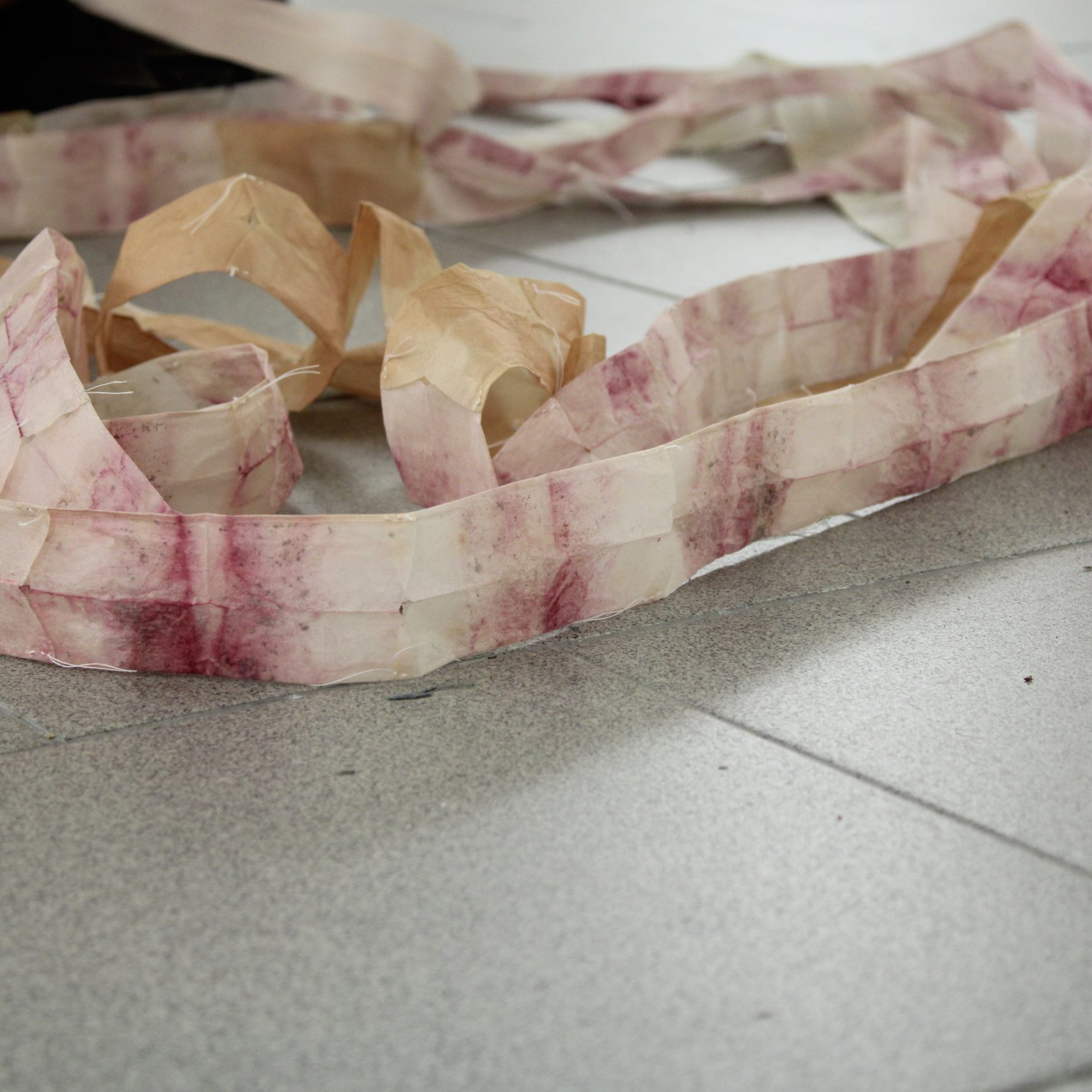 Nastro in tecnica mista di colore bianco e porpora su pavimento