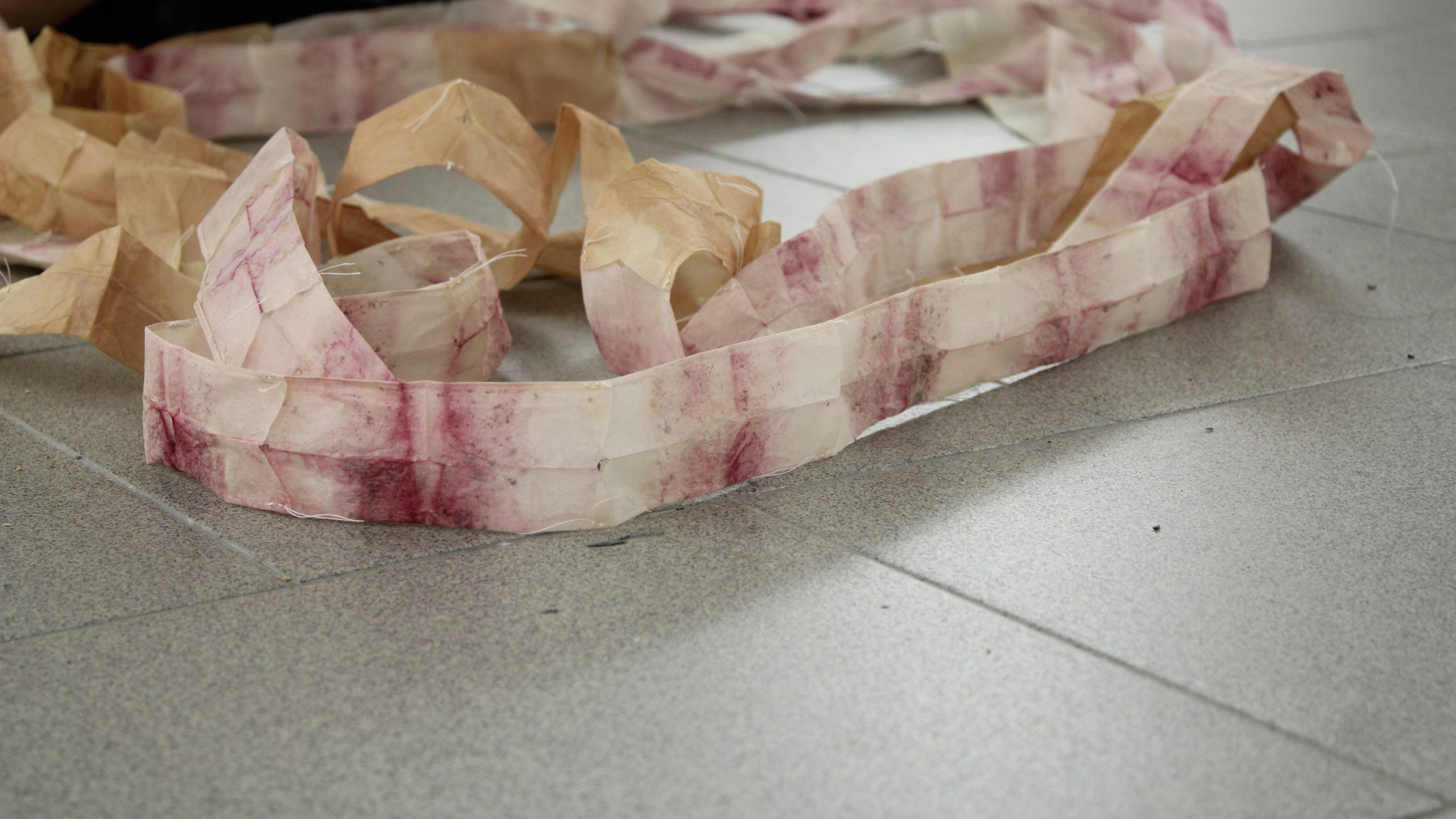 Nastro in tecnica mista di colore bianco e porpora su pavimento