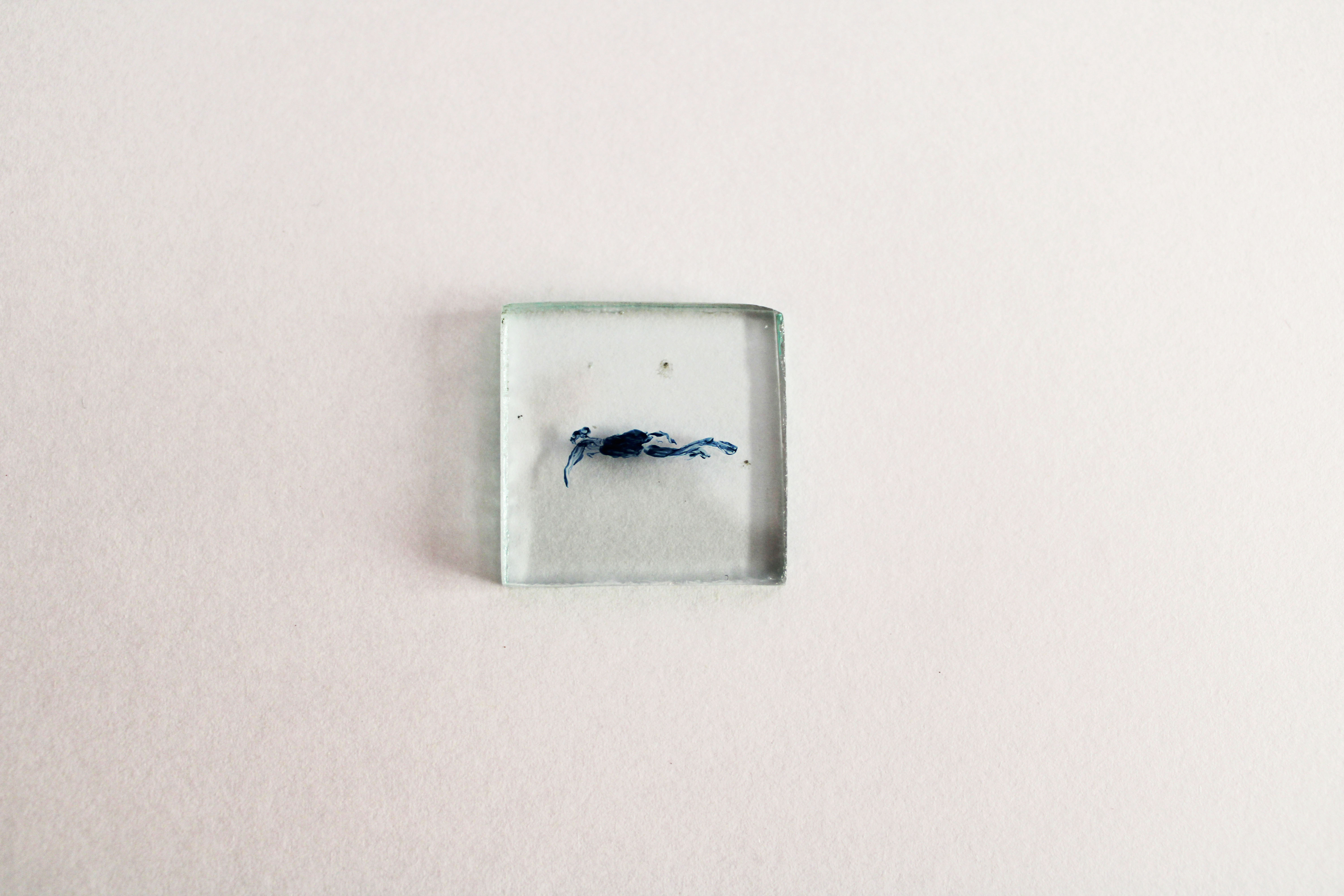 Dettaglio dell'opera su fondo bianco. Quadrato trasparente con, al centro, colore blu