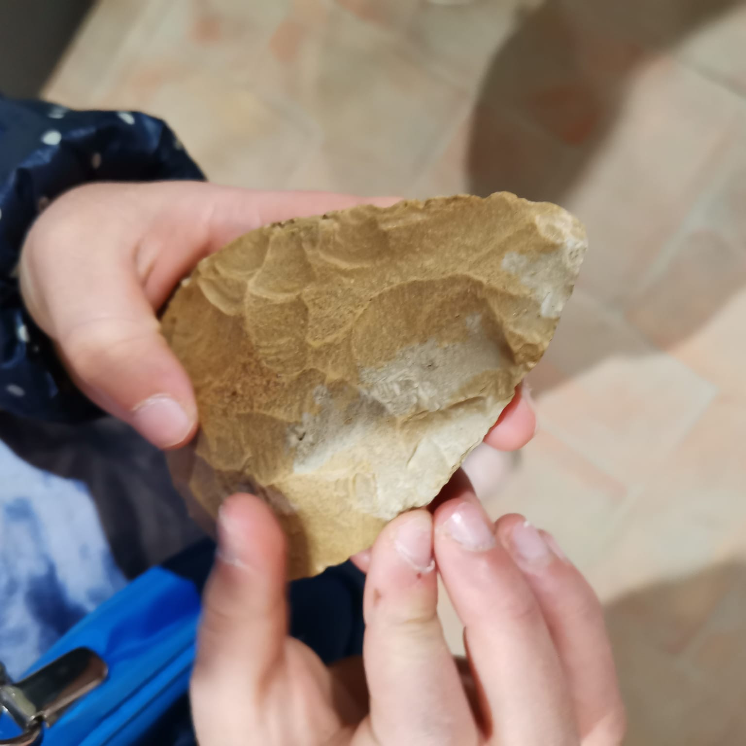 mani di bambino che hanno una scheggia preistorica