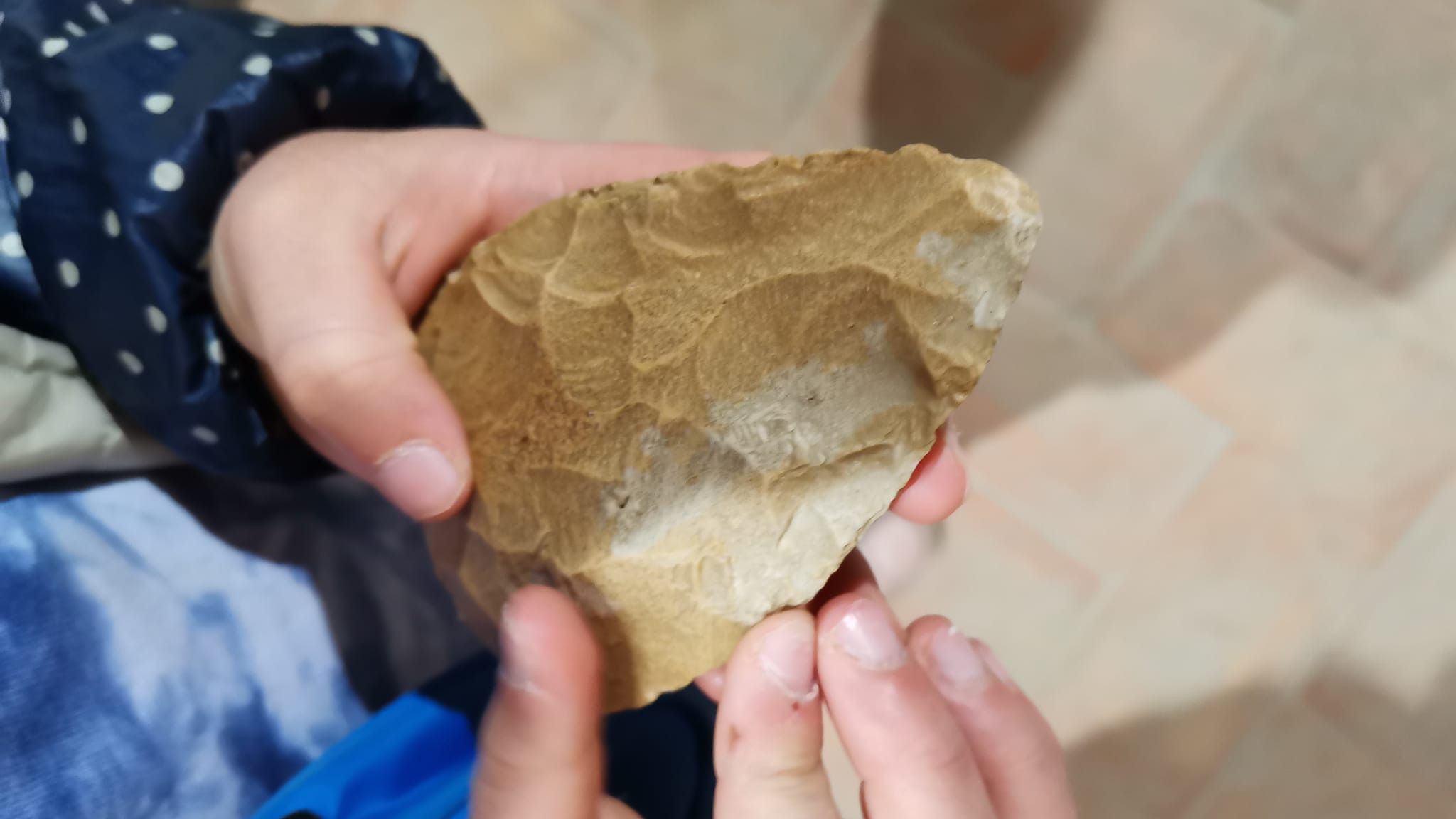 mani di bambino che hanno una scheggia preistorica