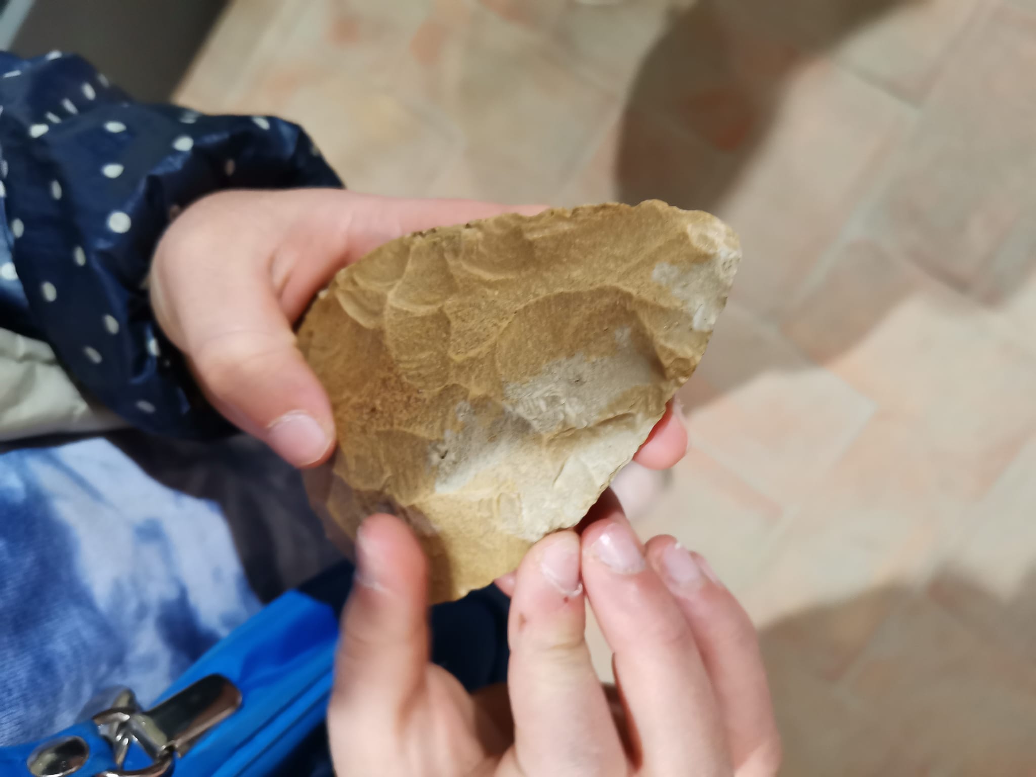 mani di bambino che hanno una scheggia preistorica